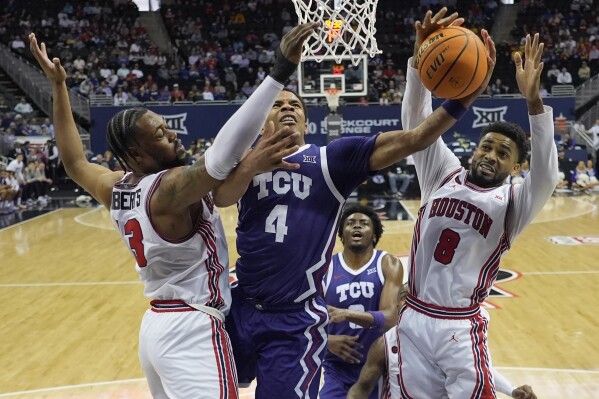 TCU guard Jameer Nelson Jr. (4) shoots between Houston forward J'Wan Roberts (13) and guard Mylik Wilson (8) during the first half of an NCAA college basketball game in the quarterfinal round of the Big 12 Conference tournament, Thursday, March 14, 2024, in Kansas City, Mo. (AP Photo/Charlie Riedel)