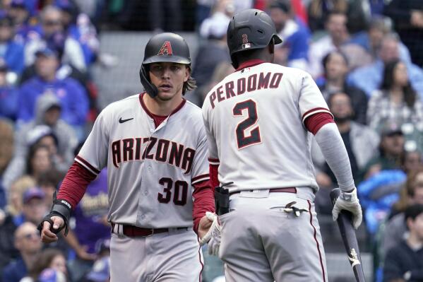 Arizona Diamondbacks' Jake McCarthy, left, celebrates with Geraldo Perdomo after scoring on a single by Alek Thomas during the seventh inning of the team's baseball game against the Chicago Cubs in Chicago, Saturday, May 21, 2022. (AP Photo/Nam Y. Huh)