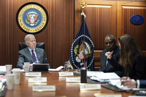 In this image provided by The White House, President Joe Biden receives the Presidential Daily Briefing, Monday, Jan. 29, 2024, in the White House Situation Room at the White House in Washington, as Defense Secretary Lloyd Austin listens. (Adam Schultz/The White House via AP)