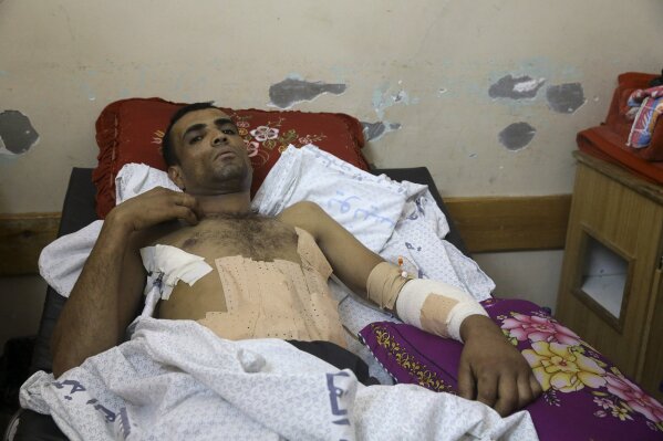 
              Marwan Shtewi, 32, lies on the bed at the surgery's ward of Shifa hospital in Gaza City, Wednesday, May 16, 2018. Shtewi was shot in his hand and abdomen by Israeli troops during a protest east of Gaza City on Monday. With few prospects and little to fear, Shtewi is among the crowds of young men who put themselves on the front lines of violent protests along the border with Israel, risking their lives in a weekly showdown meant to draw attention to the dire conditions of Gaza. (AP Photo/Adel Hana)
            