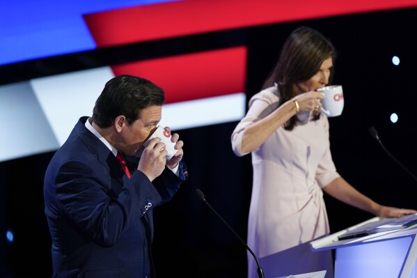 Nikki Haley, right, and Ron DeSantis, left, take a drink during a commercial break. (AP Photo/Andrew Harnik)