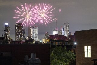 FILE - In this Friday, June 19, 2020 photo, fireworks explode during Juneteenth celebrations above the Bedford-Stuyvesant neighborhood in the Brooklyn borough of New York. The Manhattan skyline is ...