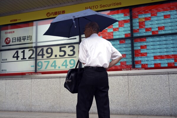 A person stops to look at an electronic stock board showing Japan's Nikkei index at a securities firm Friday, July 12, 2024, in Tokyo. (ĢӰԺ Photo/Eugene Hoshiko)