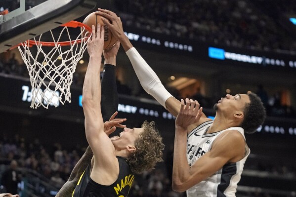 San Antonio Spurs center Victor Wembanyama, right, blocks Utah Jazz forward Lauri Markkanen, left, as he goes to the basket during the first half of an NBA basketball game Wednesday, March 27, 2024, in Salt Lake City. (AP Photo/Rick Bowmer)