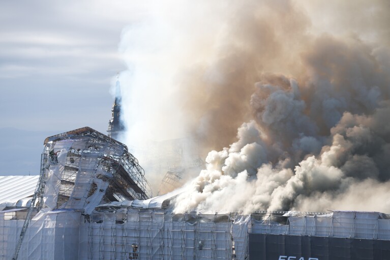 Smoke rises from the Old Stock Exchange, Boersen, in Copenhagen, Denmark, Tuesday, April 16, 2024. One of Copenhagen's oldest buildings is in flames and its iconic spire has collapsed.  The roof of the 17th-century Old Stock Exchange, or Boersen, which was once Denmark's financial center, was engulfed in flames on Tuesday.  (Emil Helms/Ritzau Scanpix via AP)