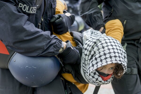 Une femme est emmenée par des policiers lors d'une manifestation pro-palestinienne du groupe "La Coalition étudiante de Berlin" Dans la cour du théâtre de l'université « Freie Universität Berlin » à Berlin, Allemagne, le mardi 7 mai 2024. Des militants pro-palestiniens ont occupé mardi une cour de l'Université libre de Berlin.  (Photo AP/Markus Schreiber)