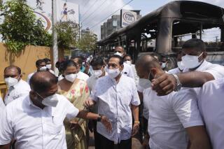 El primer ministro de Sri Lanka, Mahinda Rajapaksa, llega el viernes 1 de abril de 2022 a la residencia privada del presidente Gotabaya Rajapaksa tras los disturbios de la noche anterior en Colombo, Sri Lanka. (AP Foto/Eranga Jayawardena)