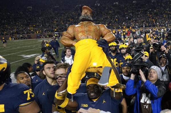 Michigan's Mike Sainristil carries the Paul Bunyan Trophy after an NCAA college football game against the Michigan State in Ann Arbor, Mich., Saturday, Oct. 29, 2022. Michigan won 29-7. (AP Photo/Paul Sancya)