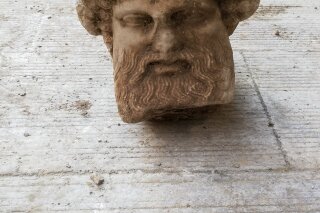 In this undated photo, provided by the Greek Culture Ministry on Sunday, Nov. 15, 2020, a head of the ancient god Hermes is pictured after being found during sewage works in central Athens. The ministry said Sunday that the head, depicting Hermes at a "mature age", one of many that served as street markers in ancient Athens, appears to be from around 300 BC, that is, either from the late 4th century BC, or the early 3rd century. (Greek Culture Ministry via AP)