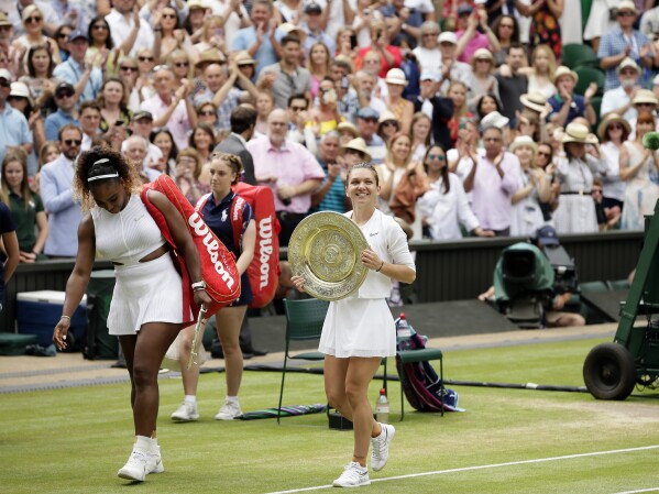FILE - Romania's Simona Halep walks away with her trophy after defeating United States' Serena Williams, left, in the women's singles final match on day twelve of the Wimbledon Tennis Championships in London, Saturday, July 13, 2019. Halep tells The Associated Press she was nervous while flying to her first tennis tournament in 1 1/2 years. She thought her career might be finished when she was given a four-year penalty by the International Tennis Integrity Agency after testing positive for the banned drug Roxadustat at the 2022 U.S. Open, where she lost in the first round. (AP Photo/Tim Ireland, File)