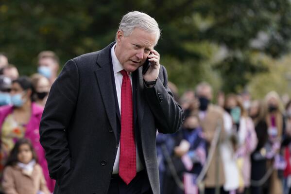 FILE - White House chief of staff Mark Meadows speaks on a phone on the South Lawn of the White House in Washington, on Oct. 30, 2020. At least 13 former Trump administration officials, including Meadows, violated the law by intermingling campaigning with their official government duties. That's according to a new federal investigation released Nov. 9, 2021. (AP Photo/Patrick Semansky, File)