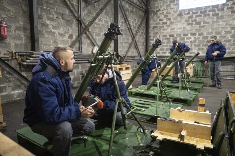 Workers check 82mm mortars at a factory in Ukraine, on Friday, December 22, 2023. (AP Photo/Evgeniy Maloletka)