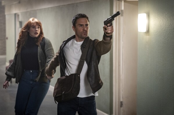 This image released by Apple shows Bryce Dallas Howard, left, and Sam Rockwell in a scene from "Argylle." (Peter Mountain/Apple-Universal Pictures via AP)
