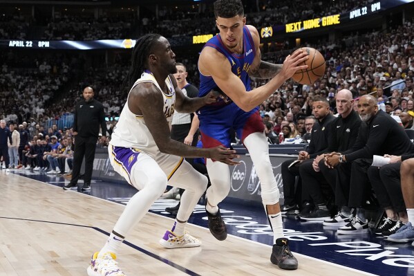 Denver Nuggets forward Michael Porter Jr., center right, is pressured by Los Angeles Lakers forward Taurean Prince, center left, during the second half in Game 1 of an NBA basketball first-round playoff series Saturday, April 20, 2024, in Denver. (AP Photo/Jack Dempsey)
