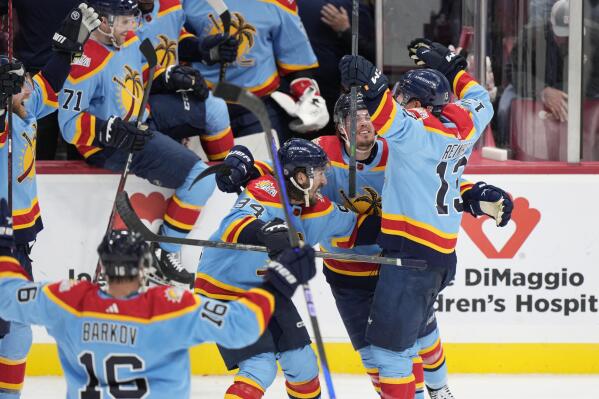 Florida Panthers center Sam Reinhart (13) is mobbed by teammates after he scored during an overtime period of an NHL hockey game to beat the Boston Bruins 4-3, Saturday, Jan. 28, 2023, in Sunrise, Fla. (AP Photo/Wilfredo Lee)