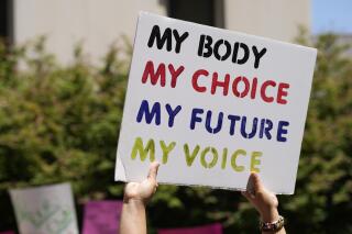 FILE - A woman supporting abortion-rights holds a sign outside the South Carolina Statehouse on July 7, 2022, in Columbia, S.C. Emboldened by the results of November's midterms, abortion rights supporters say they are preparing for even bigger fights in state legislatures and pivotal elections to come. (AP Photo/Meg Kinnard, File)