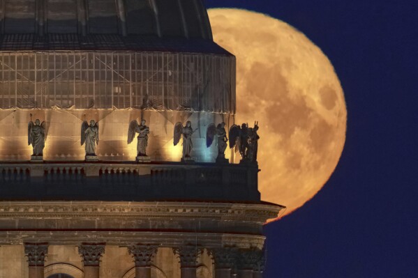 The full moon sets behind the St. Isaac's Cathedral in St. Petersburg, Russia, early Tuesday, May 13, 2025. (AP Photo/Dmitri Lovetsky)