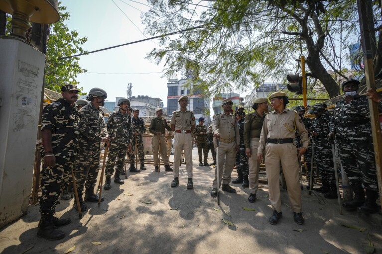 Police and paramilitary personnel stand guard outside the Assam Pradesh Congress party office to prevent a protest against the Citizenship Amendment Act (CAA) in Guwahati, India, Tuesday, March 12, 2024. India implemented a controversial citizenship law that was widely criticized , that excludes Muslims, a minority community whose fears have intensified under Prime Minister Narendra Modi's Hindu nationalist government.  The act provides fast-track naturalization for Hindus, Parsis, Sikhs, Buddhists, Jains and Christians who fled to Hindu-majority India from Afghanistan, Bangladesh and Pakistan before December 31, 2014. (AP Photo/Anupam Nath)