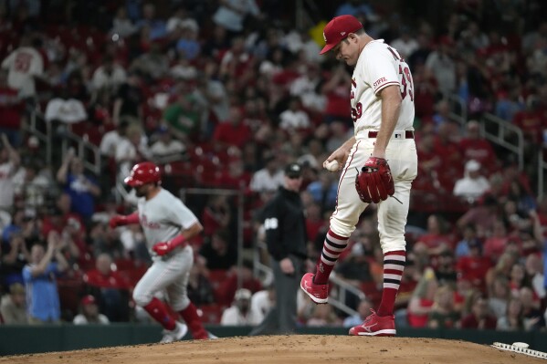 St. Louis Cardinals starting pitcher Miles Mikolas, right, kicks at the mound as Philadelphia Phillies' Kyle Schwarber rounds the bases after hitting a three-run home run during the fifth inning of a baseball game Saturday, Sept. 16, 2023, in St. Louis. (AP Photo/Jeff Roberson)