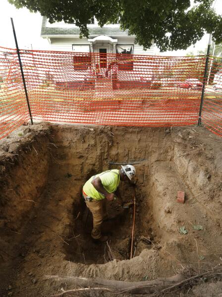 FILE-In this July 20, 2018 file photo, a worker completes a new copper water line to a house after lead pipe replacement in Flint, Mich. Michigan Gov. Gretchen Whitmer wants to spend $200 million in federal pandemic relief funding to replace lead water pipes across the state, where aging underground infrastructure was exposed by Flint's disaster. (AP Photo/Paul Sancya)