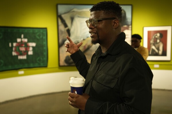 Artist Lawrence Lemaoana at an exhibition at the Apartheid Museum in Johannesburg, South Africa, Wednesday, April 24, 2024. A selection of artworks which were produced during the country's apartheid era and ended up in foreign art collections are on display to mark 30 years since the country's transition to democracy in 1994. (AP Photo/Themba Hadebe)