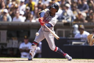 Atlanta Braves' Ozzie Albies hits into a force out during the first inning of an opening-day baseball game against the San Diego Padres Thursday, March 27, 2025, in San Diego. Atlanta Braves' Jurickson Profar scored from third base on the play. (AP Photo/Gregory Bull)