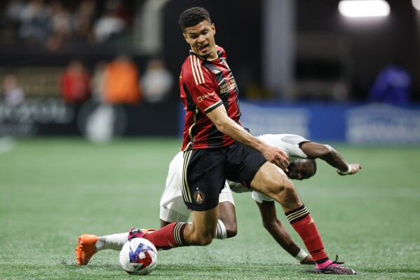 FILE -Atlanta United defender Miles Robinson, top, fields the ball past Toronto FC forward Adama Diomandé, bottom, during the first half of an MLS soccer match, Saturday, March 4, 2023, in Atlanta. Just five of 110 starting positions on the U.S. national team have been filled with Major League Soccer players for the 10 matches the full pool has been available since the 2022 World Cup, including only two of 66 since Gregg Berhalter returned as coach.(AP Photo/Alex Slitz, File)