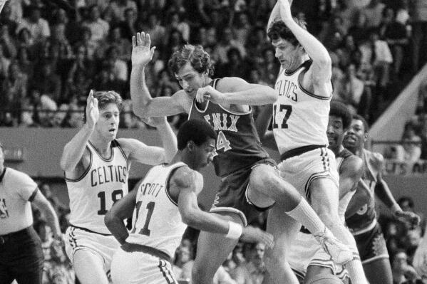 FILE - Boston's Dave Cowens, left, Charlie Scott (11) and John Havlicek team up on Paul Westphal, of the Phoenix Suns, as they try to go for a rebound during the first period of an NBA championship game at the Boston Garden, June 4, 1976. The longest game yet at the NBA Finals happened between the Boston Celtics and Phoenix Suns with the series tied at 2 apiece. (AP Photo/Peter Southwick, File)