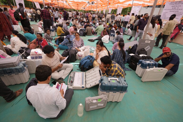 Election officials check Electronic Voting Machines(EVMs) and other polling material before they head to their respective polling booths on the eve of the third phase of India’s national elections, in Ahmedabad, Gujarat state, India, Monday, May 6, 2024. (AP Photo/Ajit Solanki)