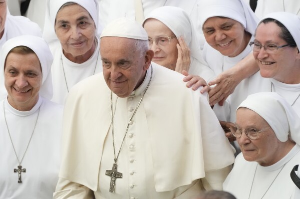 Pope Francis poses for a picture with a group of nuns during the general audience in the Paul VI hall at the Vatican, Aug. 9, 2023. (AP Photo/Gregorio Borgia)