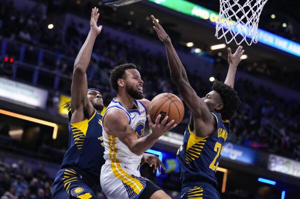 Golden State Warriors guard Stephen Curry (30) attempts a shot between Indiana Pacers center Myles Turner (33) and forward Aaron Nesmith (23) during the first half of an NBA basketball game in Indianapolis, Wednesday, Dec. 14, 2022. (AP Photo/Michael Conroy)