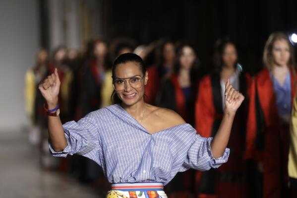 FILE - Designer Stella Jean accepts applause at the end of her womens Spring/Summer 2018/19 fashion collection, presented in Milan, Italy, on Sept. 24, 2017. Stella Jean, the only Black designer belonging to Italy’s fashion council is withdrawing from this month’s Milan Fashion Week citing a lack of commitment to diversity and inclusion, and on Wednesday Feb. 8, 2023 announced a hunger strike out of concern that other minority designers associated with her will suffer a backlash. (AP Photo/Luca Bruno, File)