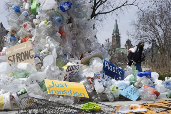 FILE - A person walks past an art installation outside a United Nations conference on plastics on April 23, 2024, in Ottawa, Ontario. (Adrian Wyld/The Canadian Press via AP, File)