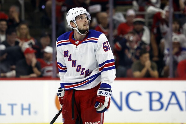 New York Rangers' Ryan Lindgren watches a replay of a power play goal by Carolina Hurricanes' Brady Skjei during the third period in Game 4 of an NHL hockey Stanley Cup second-round playoff series in Raleigh, N.C., Saturday, May 11, 2024. (AP Photo/Karl B DeBlaker)