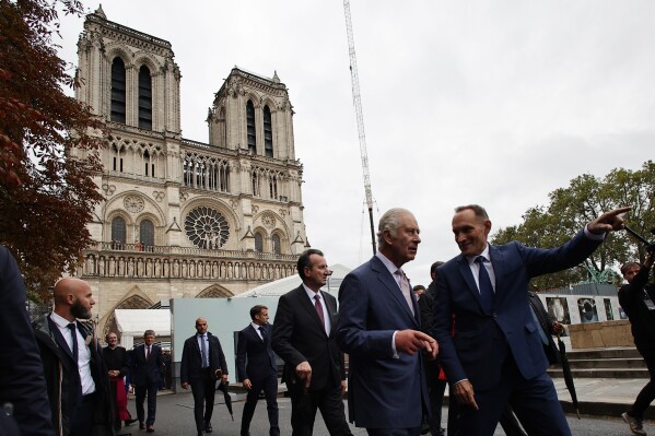 Britain's King Charles III, second right, pays a visit to the Notre-Dame de Paris Cathedral rebuilding site in Paris, Thursday, Sept, 21 2023. On the second day of his state visit to France, King Charles met with sports groups in the northern suburbs of Paris and pays a visit to fire-damaged Notre-Dame cathedral. (Christophe Petit Tesson, Pool via AP)