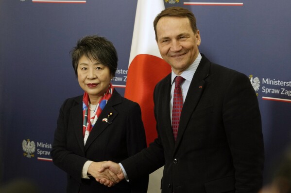 Japanese Foreign Minister Yoko Kamikawa, left, shakes hands with Polish Foreign Minister Radek Sikorski in Warsaw, Poland, on Monday Jan. 8, 2024. (AP Photo/Czarek Sokolowski)