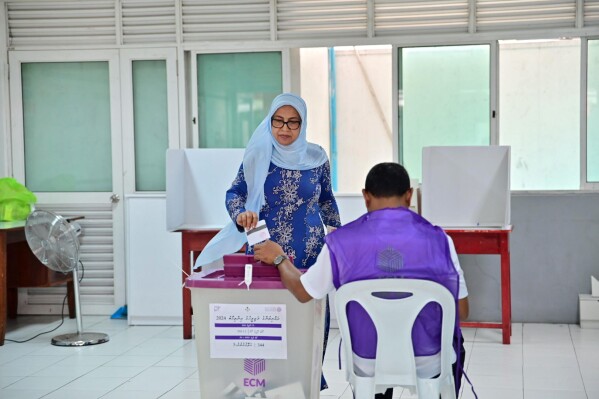 A woman casts her vote at a polling station in Male, India, Sunday, April 21, 2024. Maldivians are voting in parliamentary elections, in a ballot crucial for President Mohamed Muizzu, whose policies are keenly watched by India and China as they vie for influence in the archipelago nation. (AP Photo/Mohamed Sharuhaan)