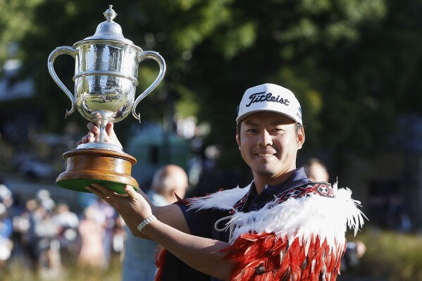 Japan's Takahiro Hataji holds his trophy aloft after winning the New Zealand Golf Open at the Millbrook Resort, in Arrowtown, New Zealand, Sunday, March 3, 2024. (Evan Barnes/Photosport via AP)