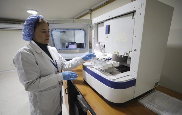 An employe of a genetic institute works with a DNA sample in Bogota, Colombia, Thursday, Nov. 14, 2019. The genetic institute through DNA tests was able to verify that two women who were given up for adoption one in Spain and other in Colombia, after the Nevado del Ruiz erupted in 1985, are sisters.(AP Photo/Fernando Vergara)
