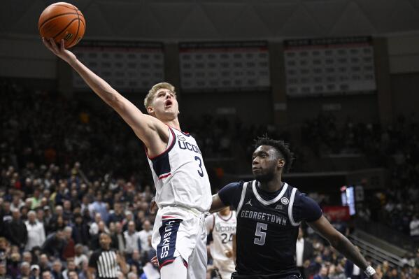 Connecticut's Joey Calcaterra (3) goes up for a basket as Georgetown's Jay Heath (5) defends in the second half of an NCAA college basketball game, Tuesday, Dec. 20, 2022, in Storrs, Conn. (AP Photo/Jessica Hill)