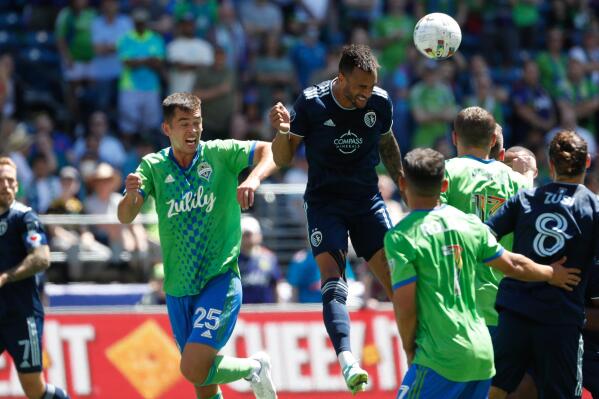 Sporting Kansas City forward Khiry Shelton, top, gets on the end of a corner kick in front of Seattle Sounders defender Jackson Ragen (25) during the first half of an MLS soccer match Saturday, June 25, 2022, in Seattle (Jennifer Buchanan/The Seattle Times via AP)
