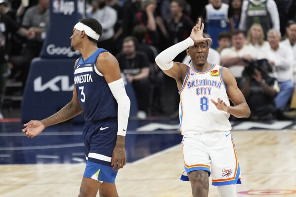 Oklahoma City Thunder forward Jalen Williams (8) gestures after making a 3-point basket next to Minnesota Timberwolves forward Jaden McDaniels (3) during the second half of Game 4 of the Western Conference finals of the NBA basketball playoffs Monday, May 26, 2025, in Minneapolis. (AP Photo/Abbie Parr)