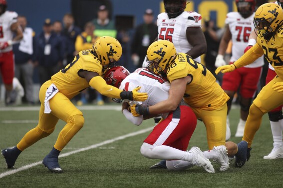 Texas Tech quarterback Tyler Shough (12) is sacked West Virginia's Edward Vesterinen (96) and Trey Lathan (19) during the first half of an NCAA college football game, Saturday, Sept. 23, 2023, in Morgantown, W.Va. (AP Photo/Chris Jackson)