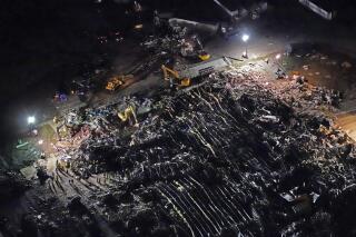 In this aerial photo, a collapsed factory is seen with workers searching for survivors, Saturday, Dec. 11, 2021, in Mayfield, Ky., after tornadoes came through the area the previous night. (AP Photo/Gerald Herbert)
