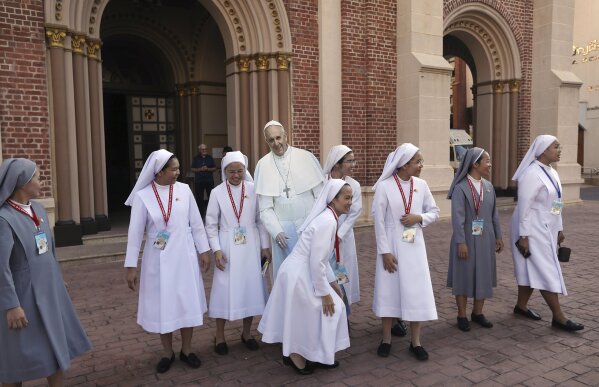 Catholic nuns surround a life size cut out of Pope Francis at the Assumption Cathedral in Bangkok, Thailand, Wednesday, Nov. 20, 2019. Pope Francis is heading to Thailand to encourage members of a minority Catholic community in a Buddhist nation and highlight his admiration for their missionary ancestors who brought the faith centuries ago and endured persecution. (AP Photo/Manish Swarup)