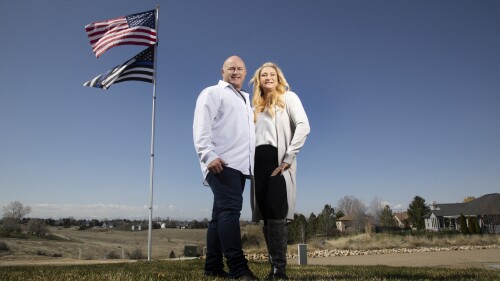 Jennifer and Tim Kohl poses for a photo in their front yard with the American flag and a thin blue line flag in Star, Idaho, on April 14, 2023. The couple recently moved to Idaho from the Los Angeles area. Americans are segregating by their politics at a rapid clip, helping fuel the greatest divide between the states in modern history. (AP Photo/Kyle Green)