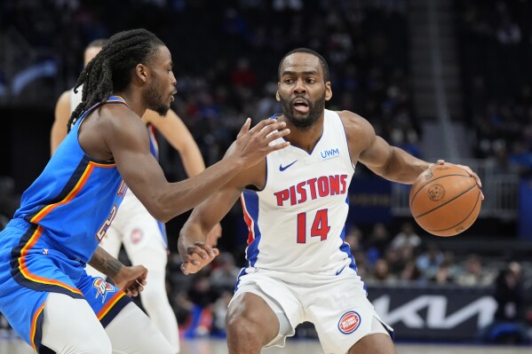 Detroit Pistons guard Alec Burks (14) is defended by Oklahoma City Thunder guard Cason Wallace (22) during the first half of an NBA basketball game, Sunday, Jan. 28, 2024, in Detroit. (AP Photo/Carlos Osorio)