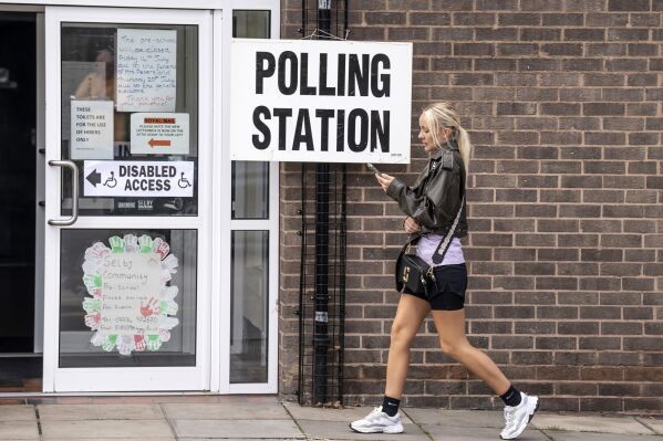 A woman walks past a polling station sign outside Selby Community Centre in Selby North Yorkshire, during voting for the Selby and Ainsty by-election, called following the resignation of incumbent MP Nigel Adams, Thursday July 20, 2023. The polls have opened in three by-elections where defeats would heighten Conservative fears that Rishi Sunak will struggle to lead them to another Commons majority. (Danny Lawson/PA via AP)