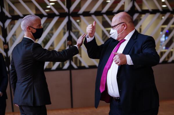 Germany's Economy and Energy Minister Peter Altmaier, right, greets France's Foreign Trade Minister Franck Riester prior to a European Foreign Trade ministers meeting at the European Council headquarters in Brussels, Thursday, May 20, 2021. (AP Photo/Francisco Seco, Pool)