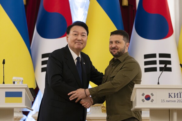 South Korean President Yoon Suk Yeol, left, and Ukrainian President Volodymyr Zelenskyy stand for photos after delivering statements, Saturday, July 15, 2023, in Kyiv, Ukraine. (AP Photo/Jae C. Hong)